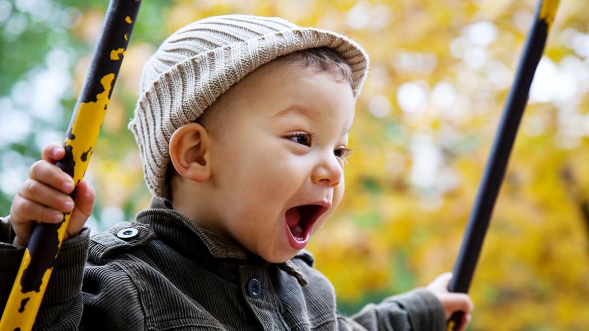 Young child smiling on swing