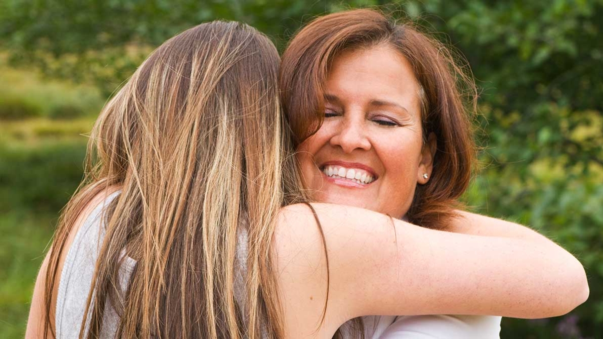 Mum hugging her teenage daugher